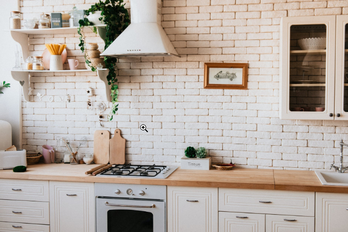 a bright kitchen with white brick wall